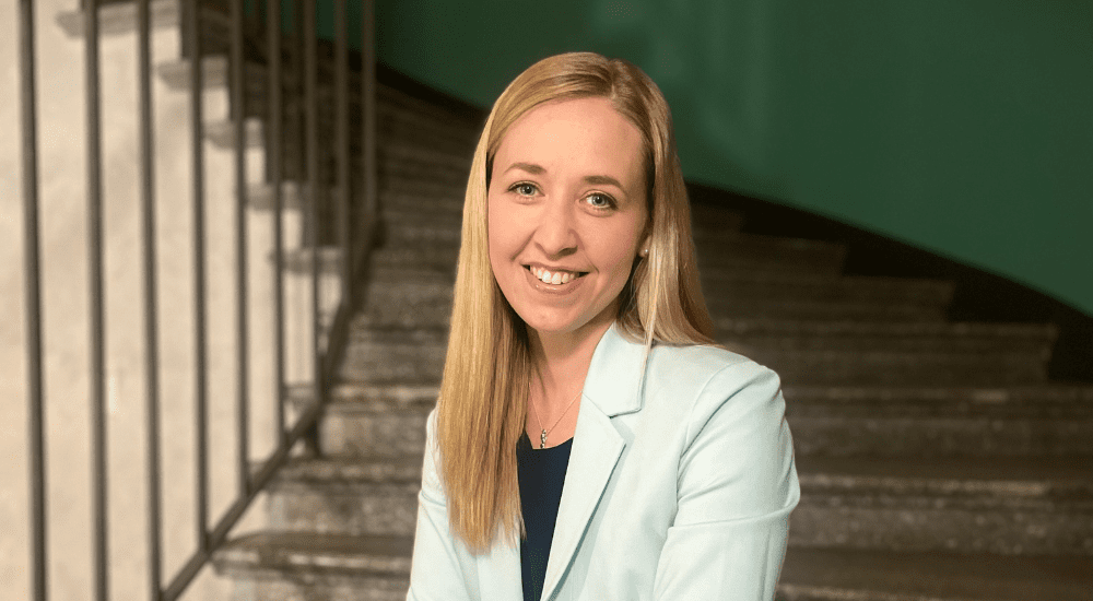 Portaikossa istuva nainen hymyilee