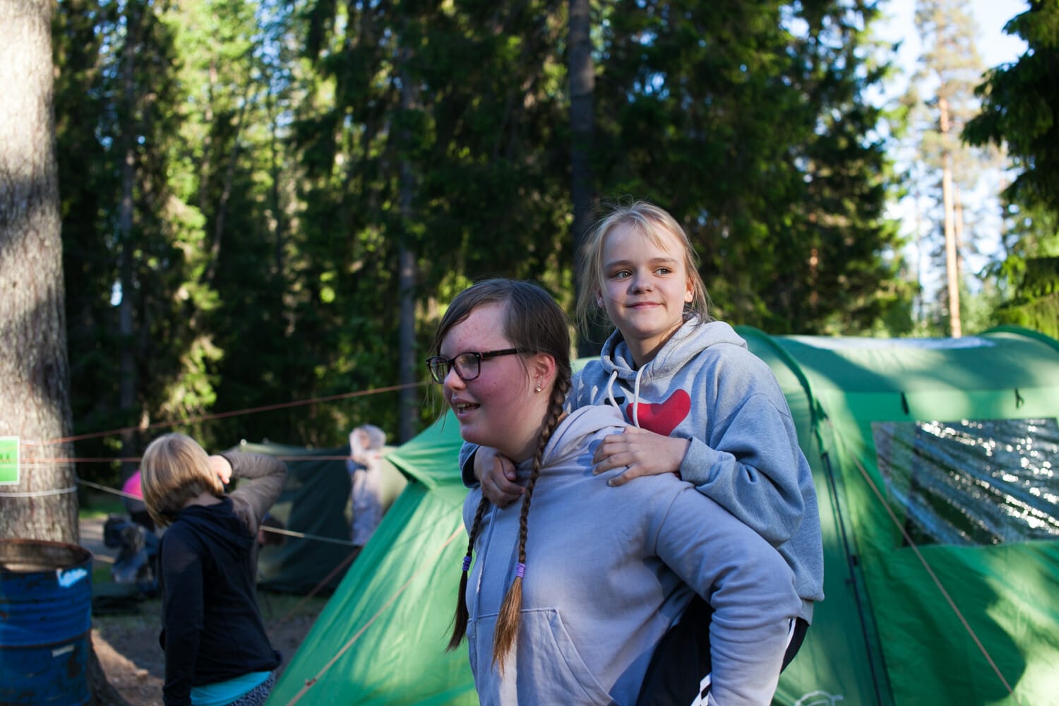 Lapsi naisoletetun henkilön reppuselässä.