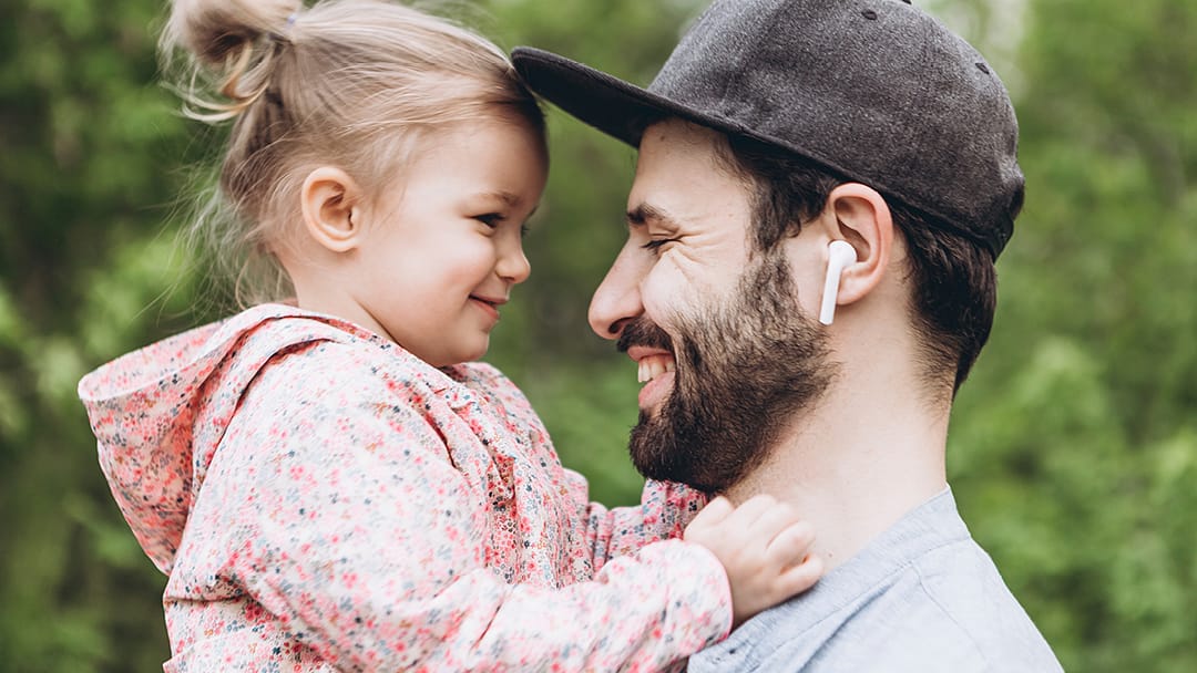 Miesoletettu henkilö ja pieni lapsi sylissä.