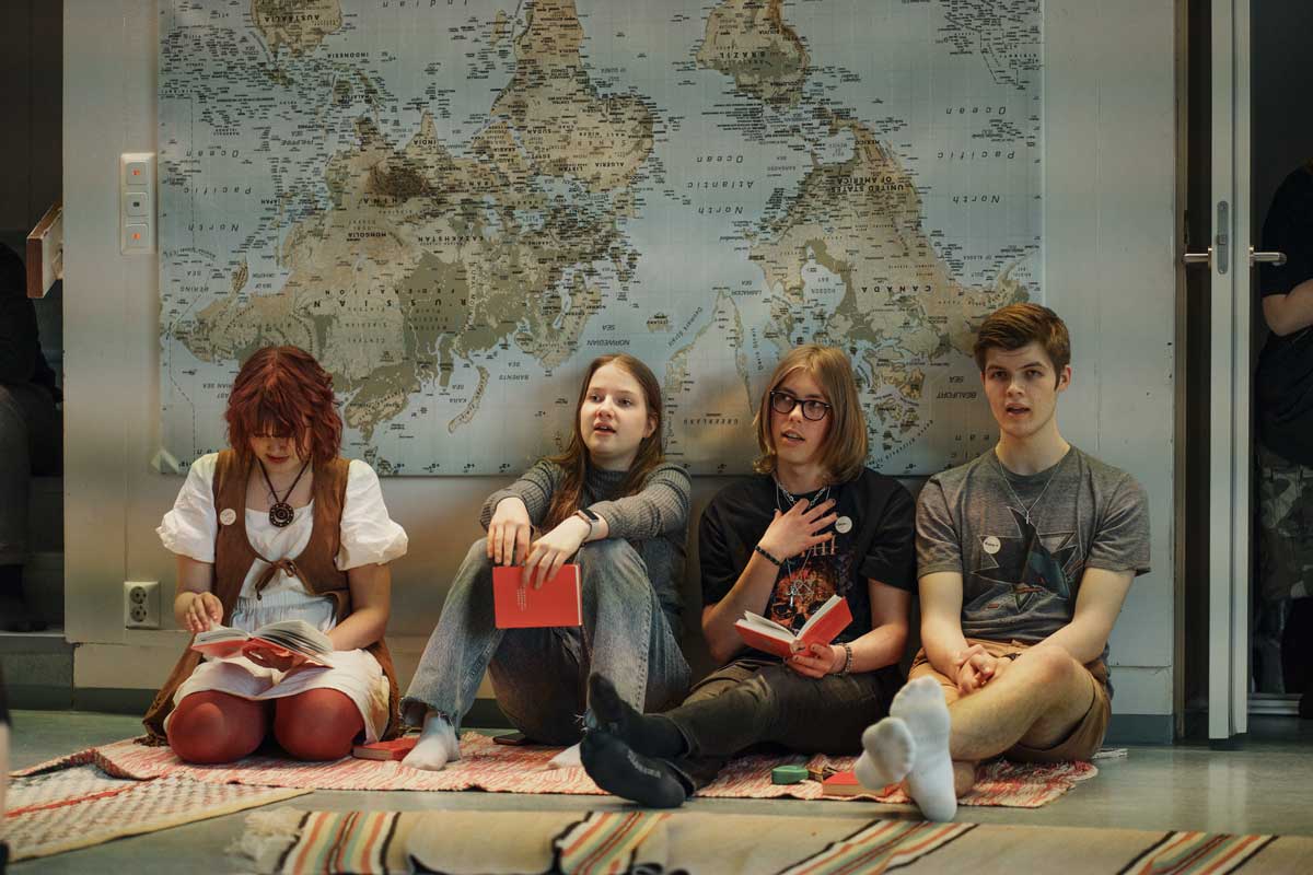 Nuoria istumassa nojautuen seinään.