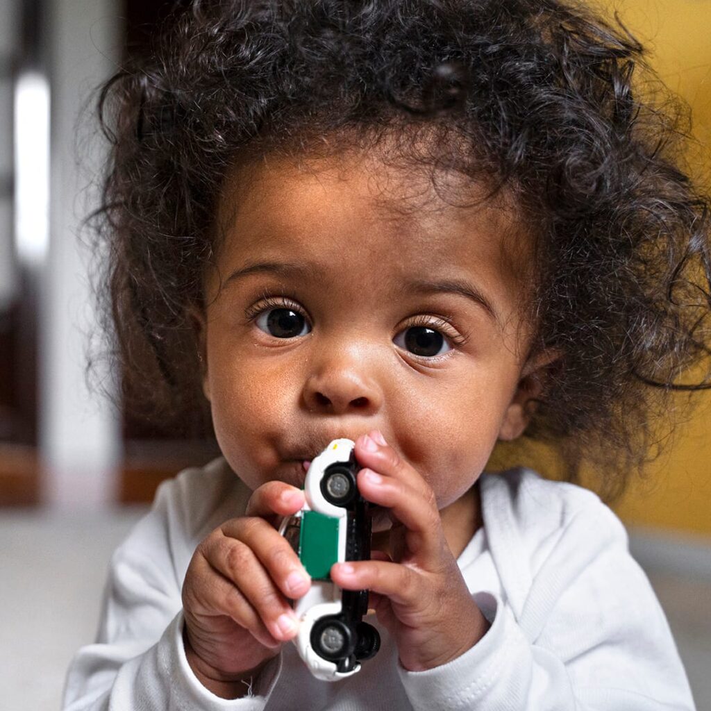 Pieni lapsi leikkiauton kanssa.