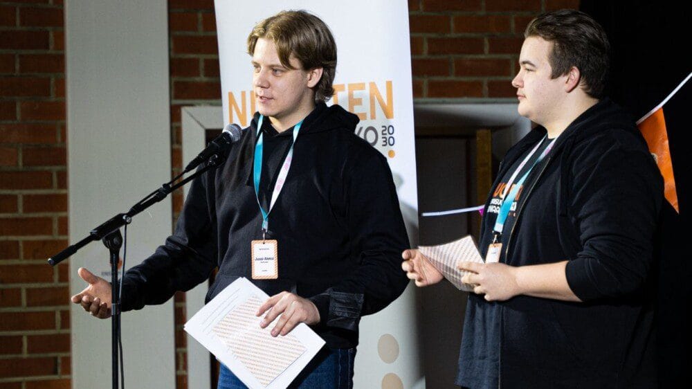 Nuoria puhumassa lavalla.