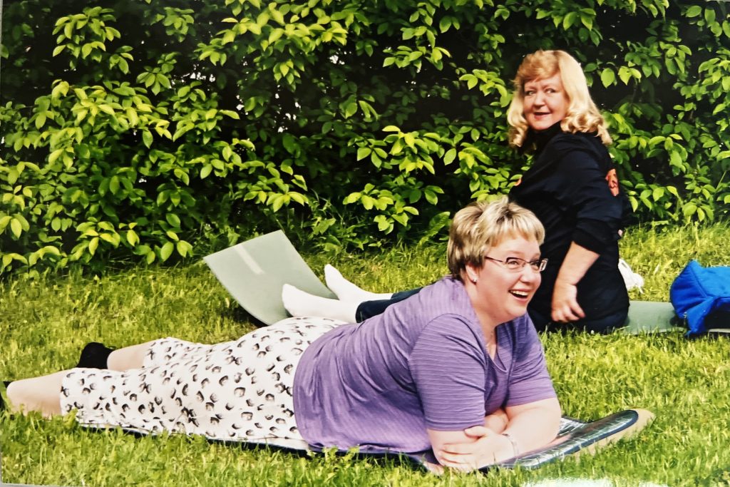 Kaksi naisoletettua henkilöä nurmikolla.