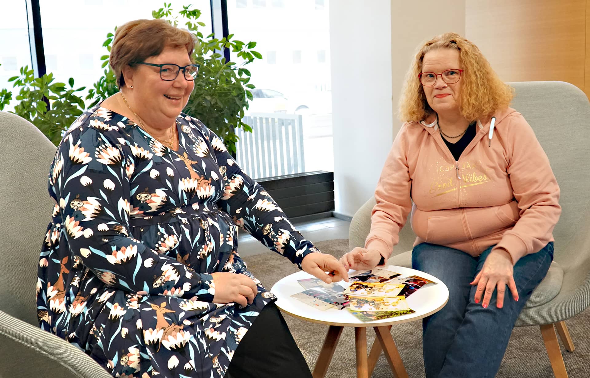 Kaksi naisoletettua henkilöä istumassa pöydän vieressä.