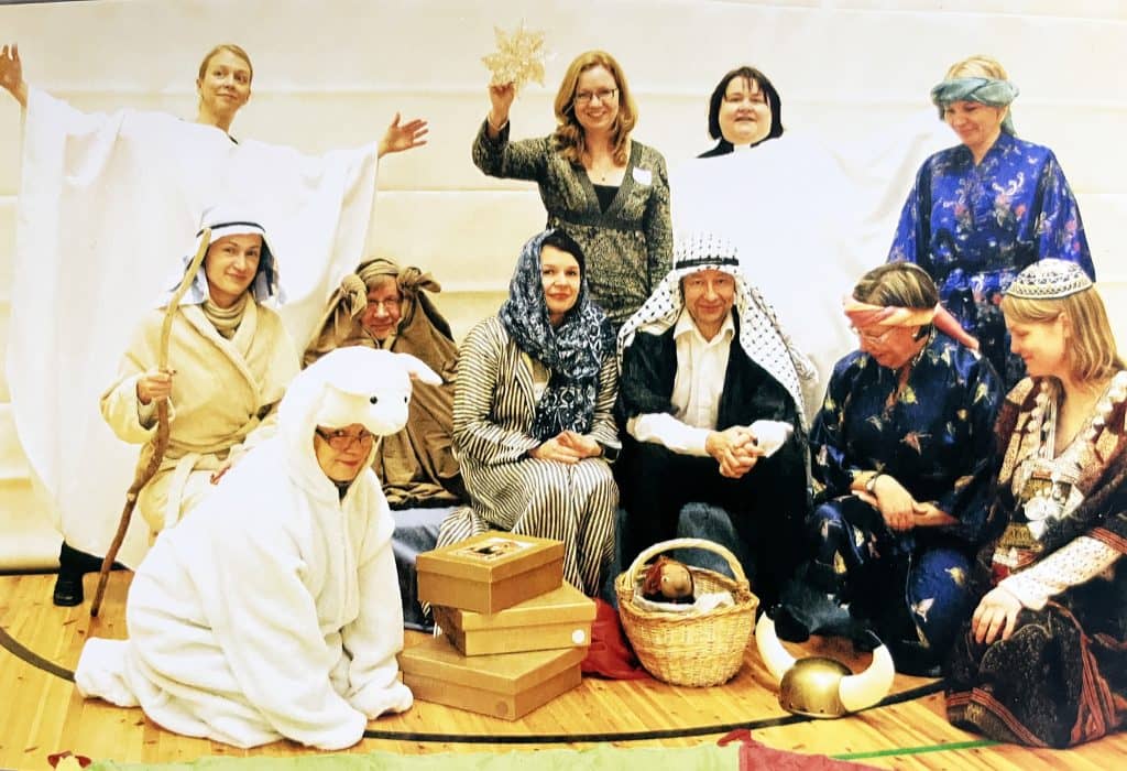 Ihmisiä jouluasetelmassa.