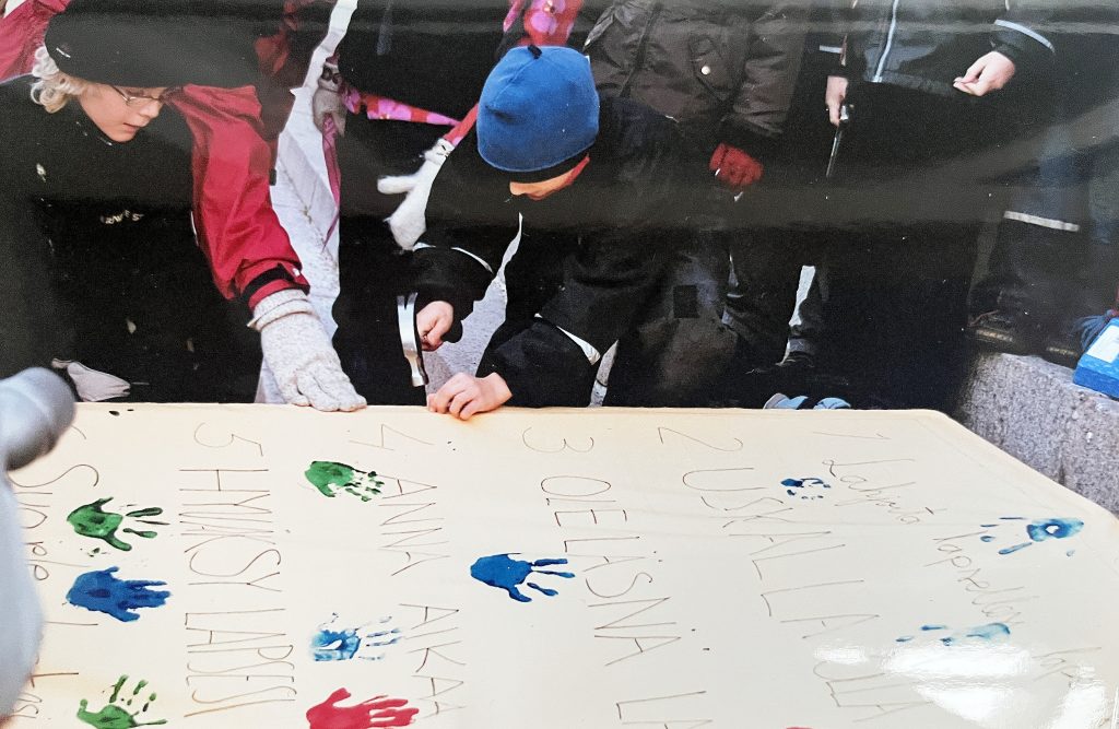 Lapset naulaamassa suurta paperia.