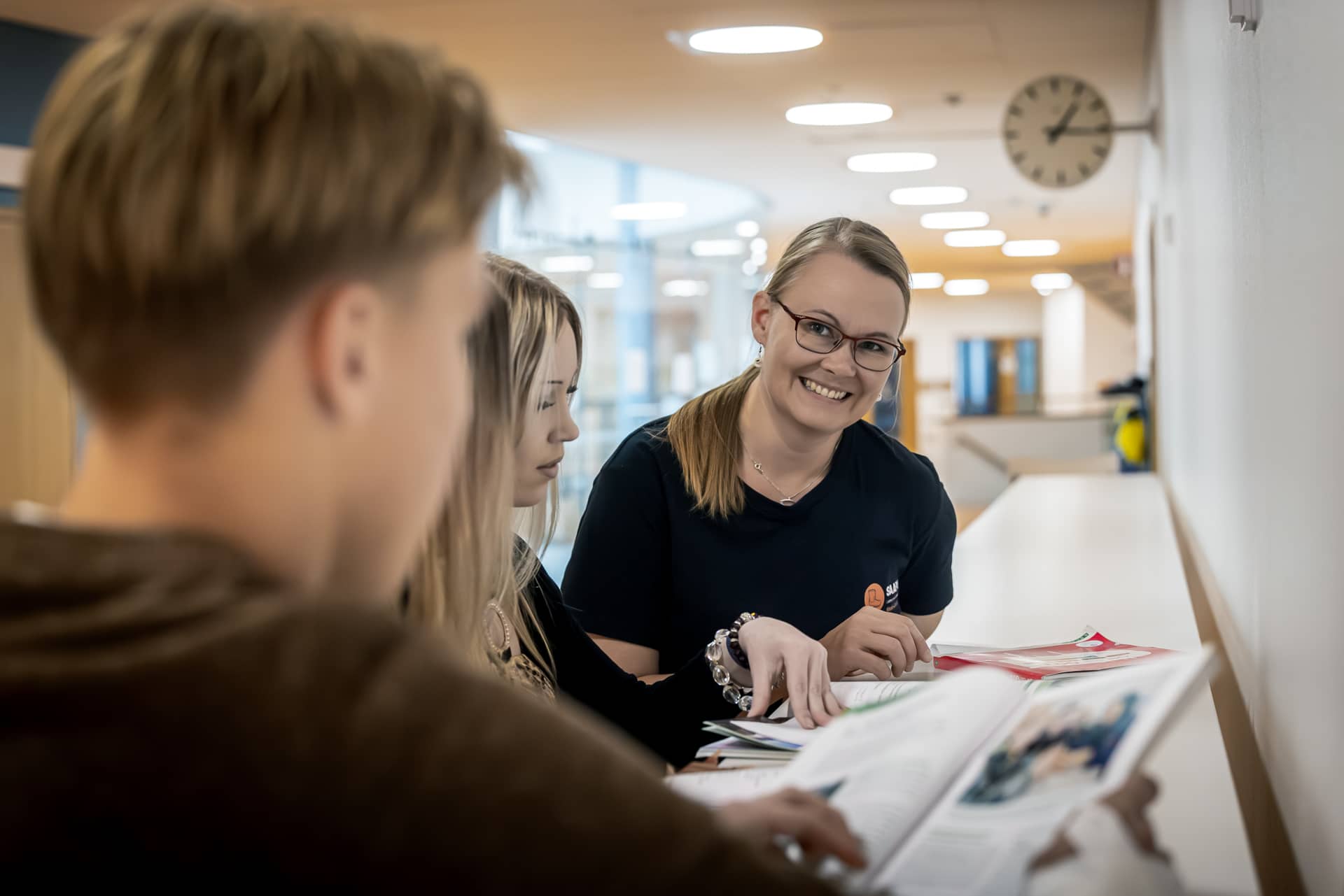 Nuori henkilöitä seisomassa pöydän vieressä.